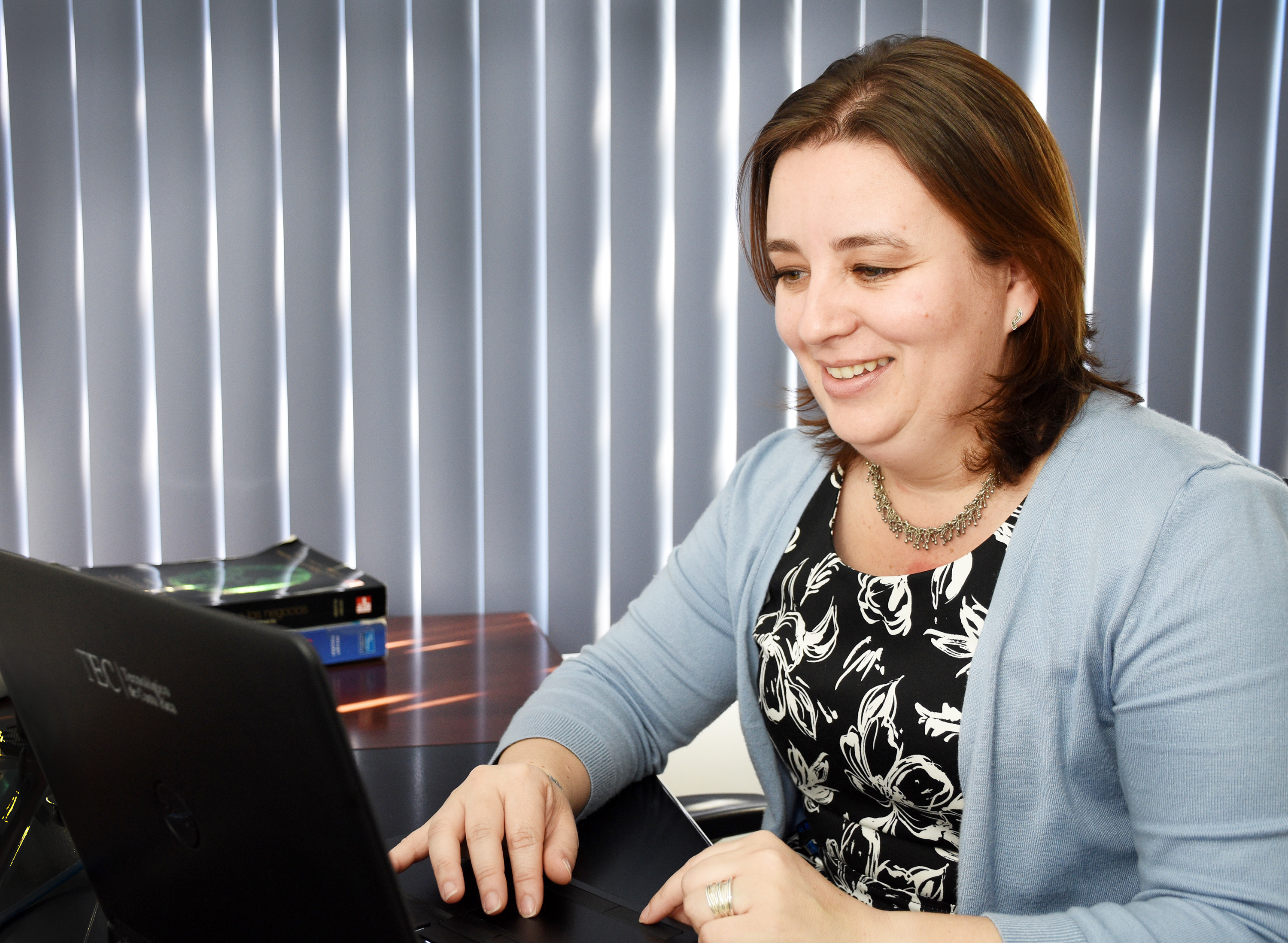 Profesora viendo una computadora.