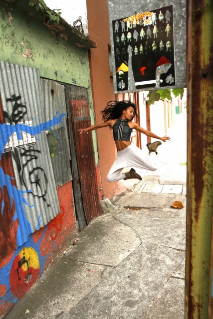 Mujer dando un salto de danza en una acera de Barrio Amón.