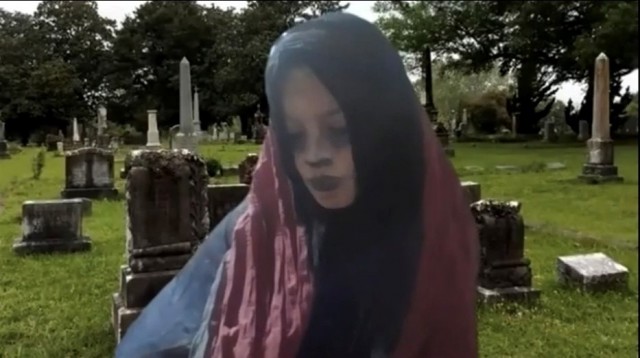 Mujer de luto en medio de un cementerio