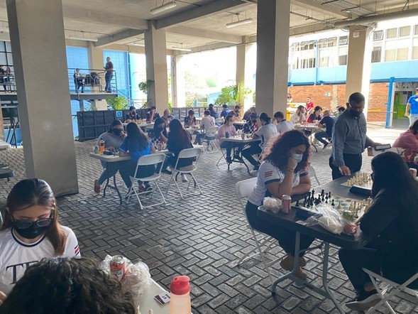 Varias parejas de jugadores en plena partida de ajedrez en el estacionamiento bajo techo del TEC en San José