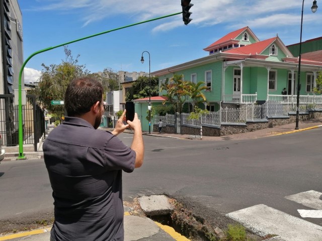 Un hombre apunta con su teléfono celular hacia la Casa Verde del TEC para obtener datos adicionales del inmueble gracias a la tecnología de la realidad aumentada