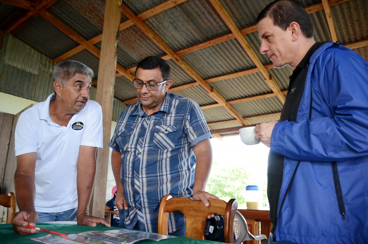 Los tres hombres están reunidos alrededor de un mapa.