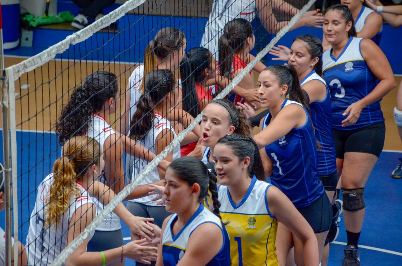 Jugadoras de Voleibol saludandose en la cancha.