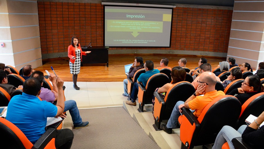 mujer frente a un auditorio hablando