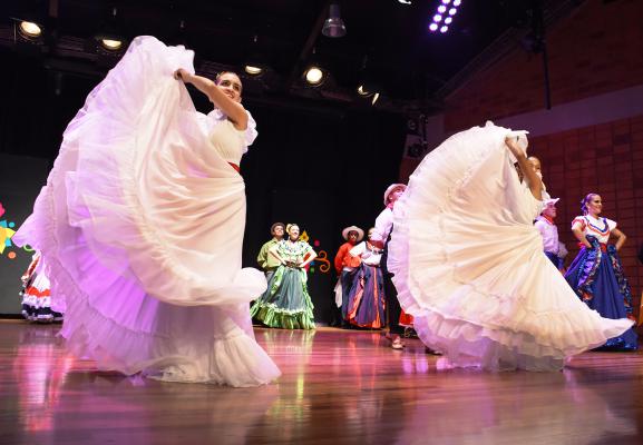 Dos mujeres bailan durante la inauguración del festival con sus trajes típicos