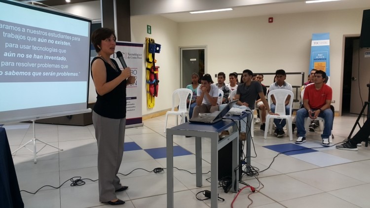 mujer de pie con micrófono dando clases