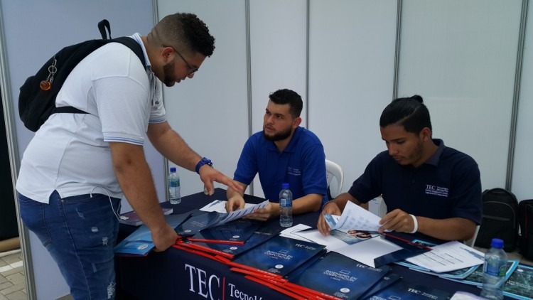 Joven de pie consultando información de las carreras del TEC