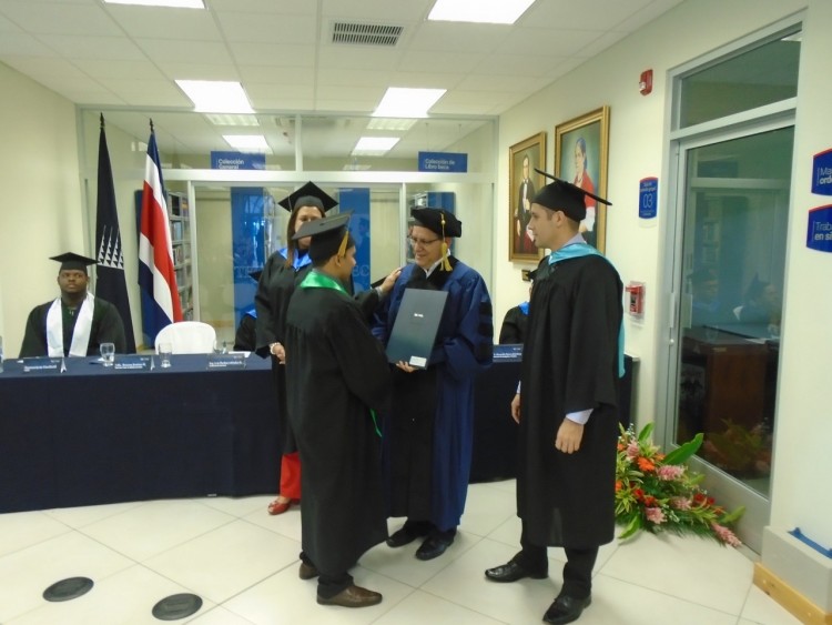 estudiante con toga recibiendo el título. 