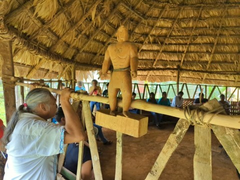 un hombre indígena observa desde fuera una presentación.