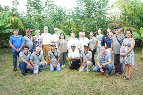 Un grupo de personas posan frente a la plantación.