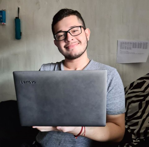 imagen de un estudiante con una computadora en sus manos.
