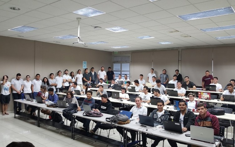 Grupo de estudiantes integrantes de la Comunidad de Aplicaciones Móviles reunidos en un aula.