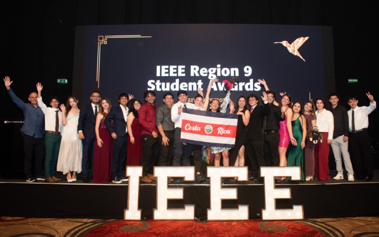 Estudiantes en el escenario con las letras IEEE