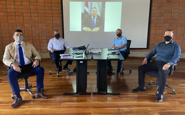 La fotografía muestra parte de la reunión en el edificio D3. Los ejecutivos sentados en su silla, frente a una mesa. 