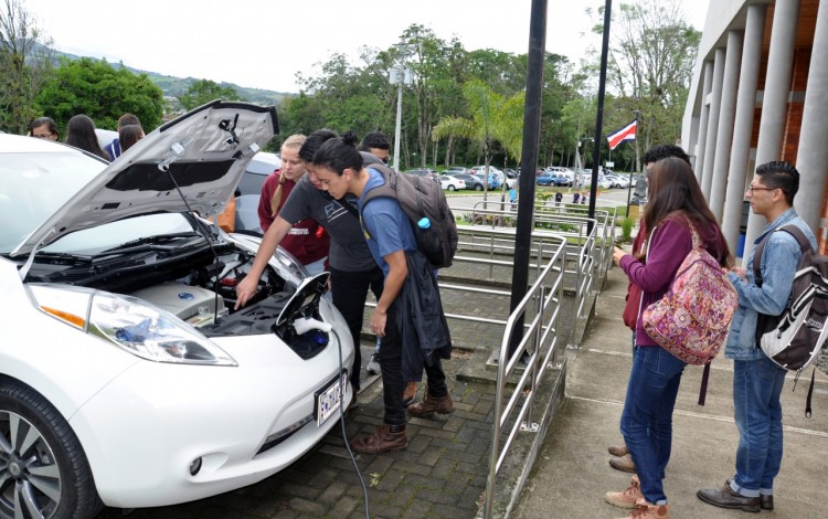 Un grupo de estudiantes observan un auto eléctrico. 