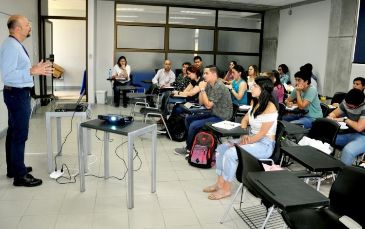 El especialista expone frente a una clase de jóvenes. 