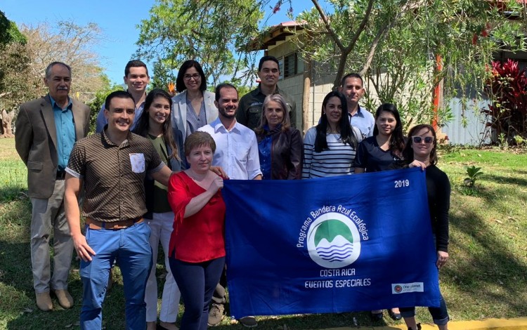 imagen de varias personas posando para la fotografía con la Bandera Azul Ecológica.