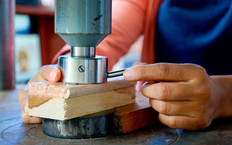 Mano de hombre cortando madera.