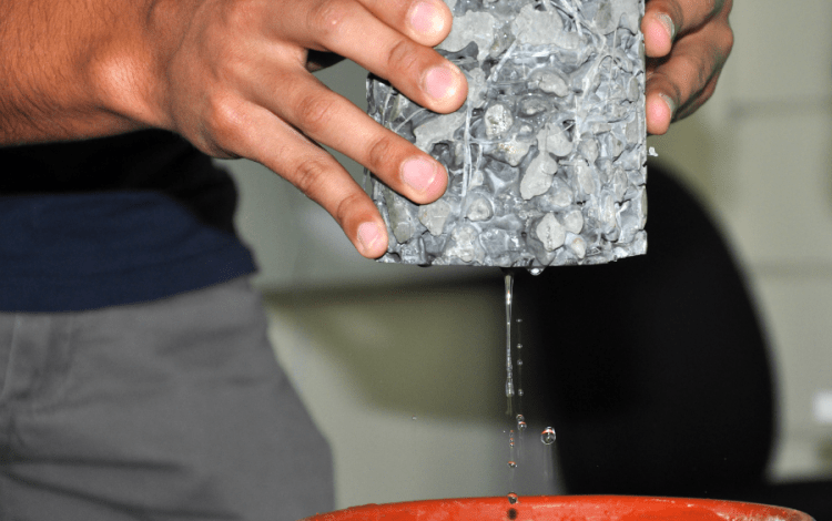 Demostración de agua siendo filtrada por concreto permeable.