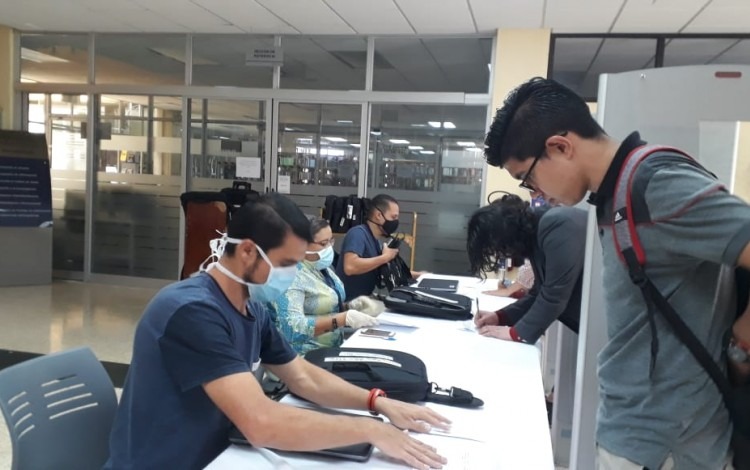 Estudiantes recogiendo computadora prestada.