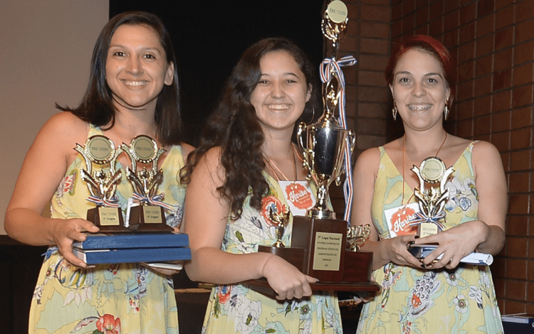 Imagen de tres mujeres con un trofeo