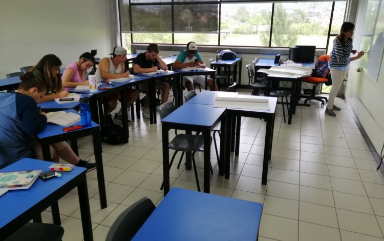 Estudiantes sentados en el aula recibiendo la clase