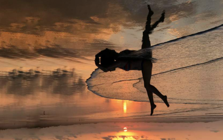 Reflejo de una mujer en la playa