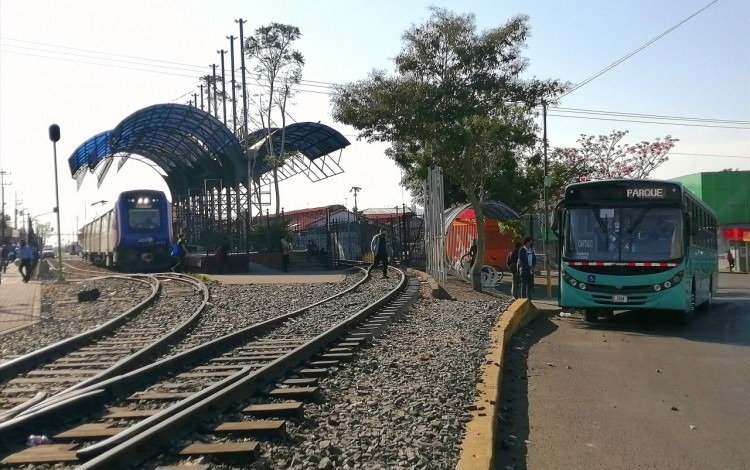 Se observa el tren en la estación y el bus en la parada. 