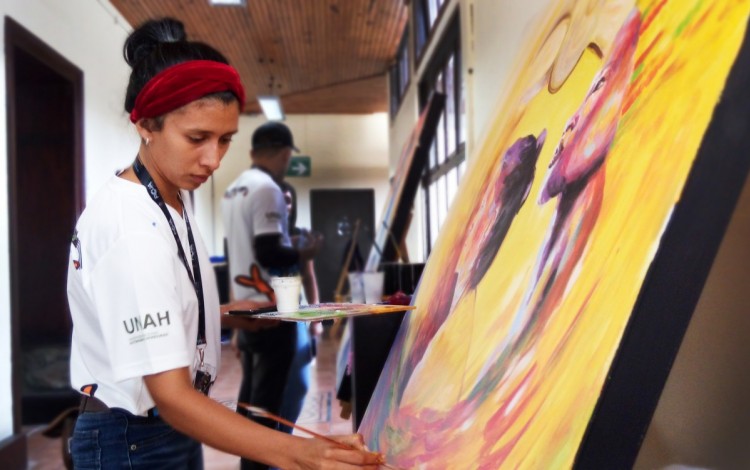 Imagen de una estudiante hondureña pintando en Casa de la Ciudad.