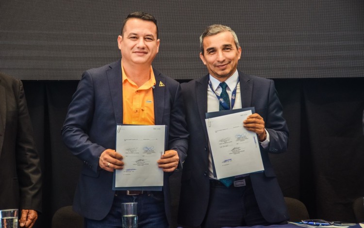 Dos hombres posando con el convenio.