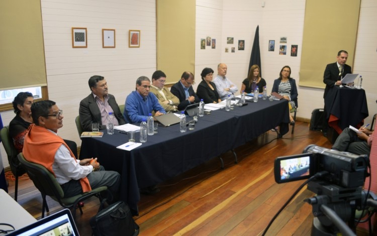 Se muestra la sala de la Casa Cultural, con los candidatos sentados en una mesa larga.