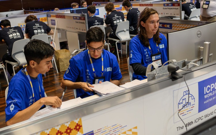 Imagen de tres estudiantes en la competencia.