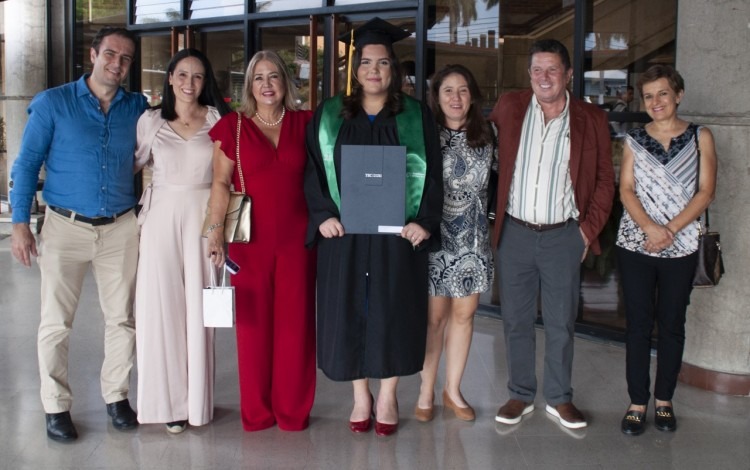 Imagen de la estudiante graduada junto a sus familiares