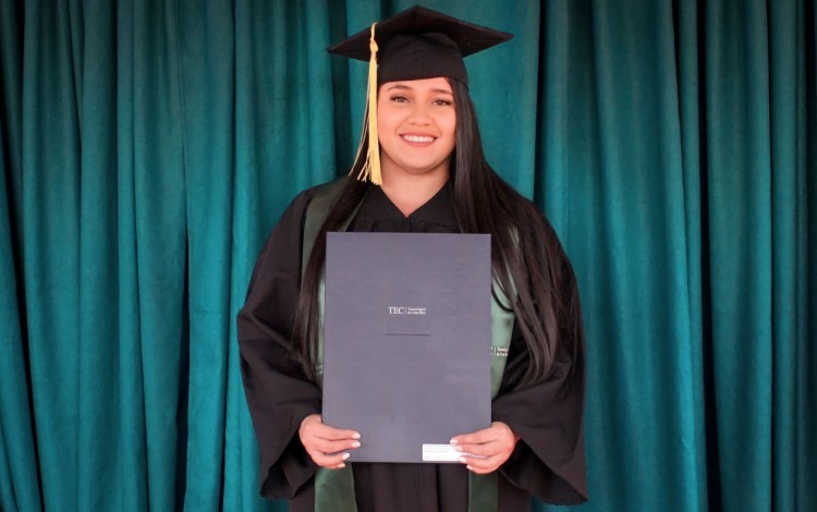 Imagen de una estudiante con el título universitario.