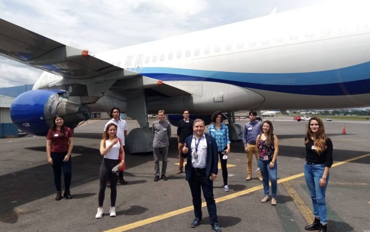 Grupo de estudiantes posando frente a un avión.