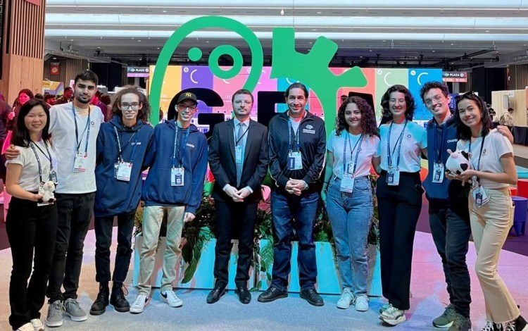 Los jóvenes posan frente al logo de iGEM.