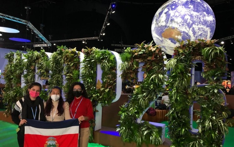 imagen de tres estudiantes con la bandera de Costa Rica, en una conferencia internacional, en Escocia.