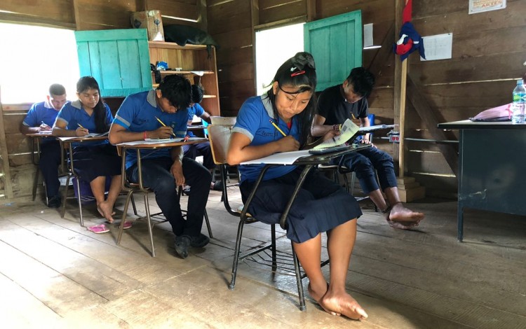 estudiantes indígenas en un escritorio haciendo examen.  