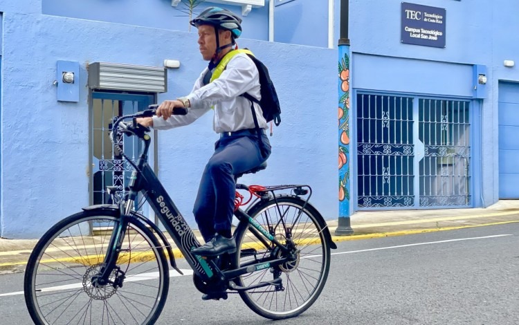 Chofer del TEC monta la bicicleta en la calle, para mostrar como realiza ahora su trabajo.