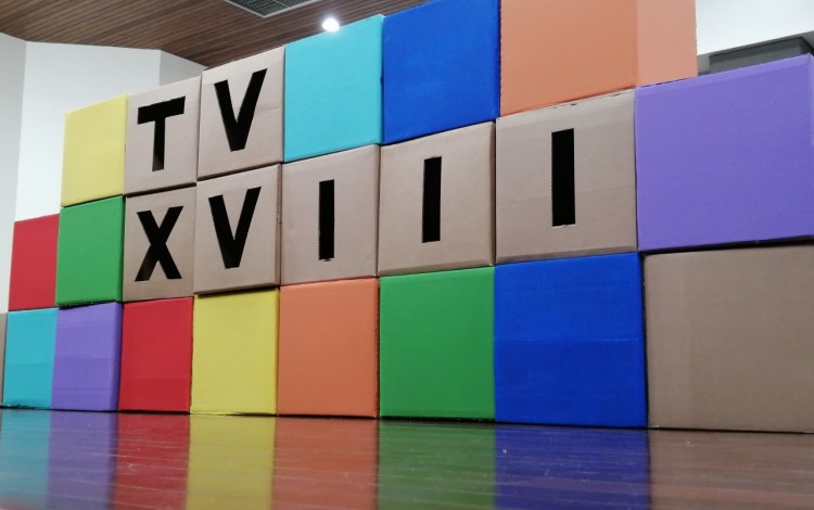 Conjunto de cubos de colores con el nombre del taller que se ubicaron en el escenario del auditorio del Tribunal Supremo de Elecciones como parte de la decoración durante la inauguración del Taller Vertical 2022.