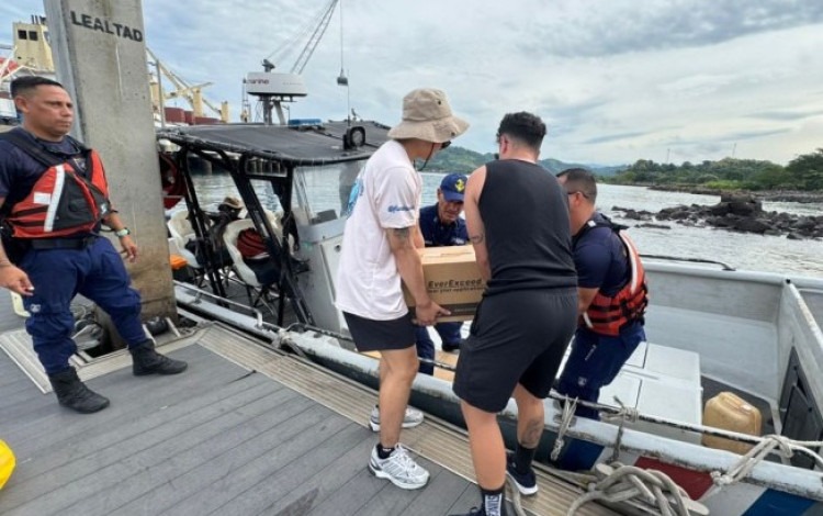 Imagen de 5 personas trabajando en Isla Caballo. Están cargando la lancha con donaciones.