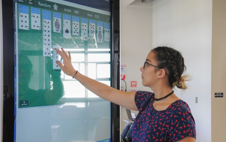 Mujer jugando cartas en la pantalla  de los kioscos informativos del kioscos informativos.