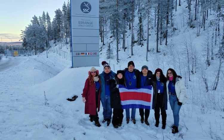 Los jóvenes posan con la bandera de Costa Rica en la entrada al puerto espacial.