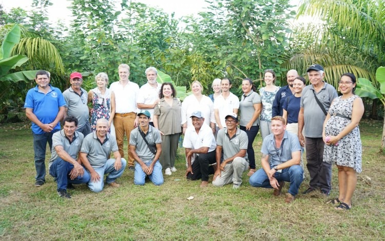 Un grupo de personas posan frente a la plantación.