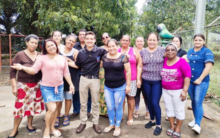 El estudiante posa con un grupo de cerca de 20 mujeres.