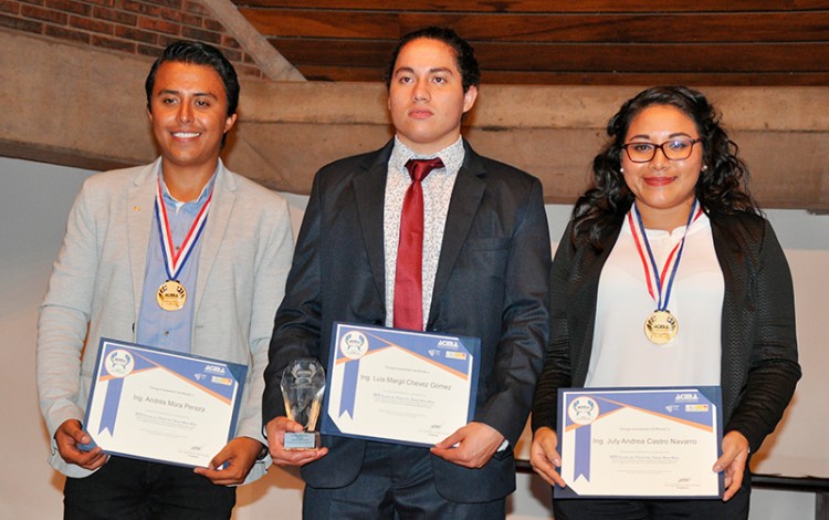 Tres estudiantes, dos hombres y una mujer, posan con sus títulos.