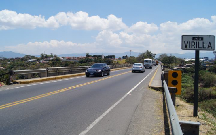 Carro pasando por el puente del Río Virilla 