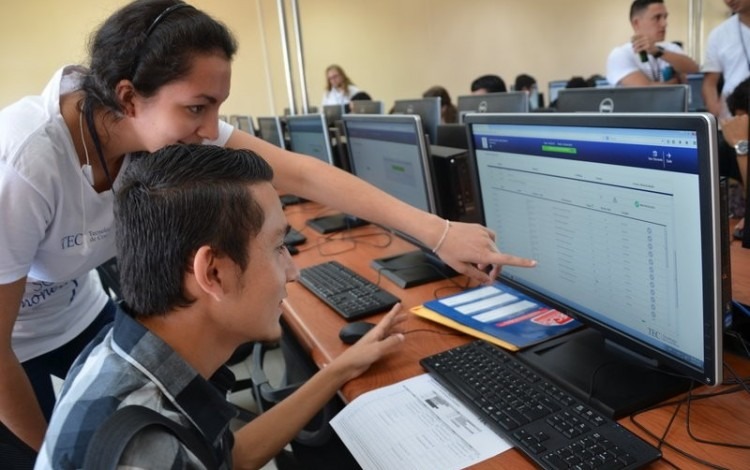 estudiantes frente a computadora señalando monitor