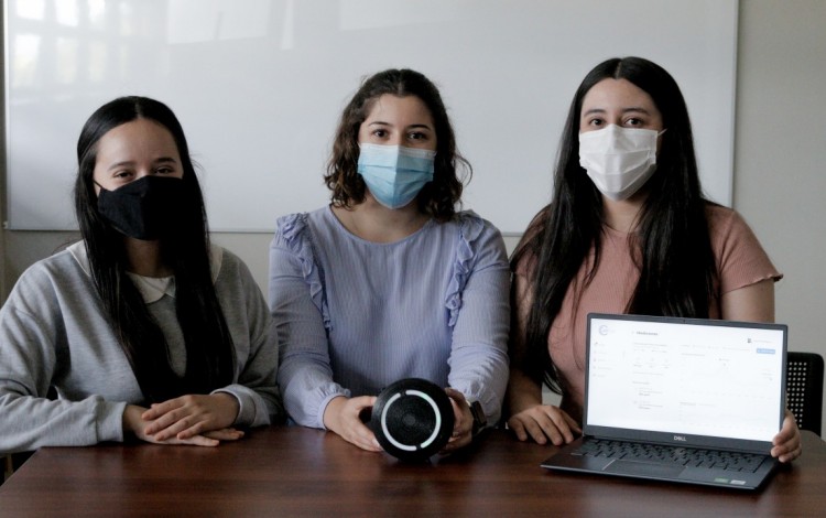 Imagen con tres estudiantes mostrando el dispositivo que mide el dióxido de carbono (CO2) en espacios cerrados