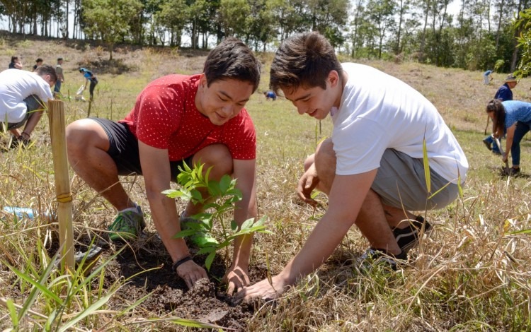 Imagen de dos estudiantes del TEC plantando un árbol.